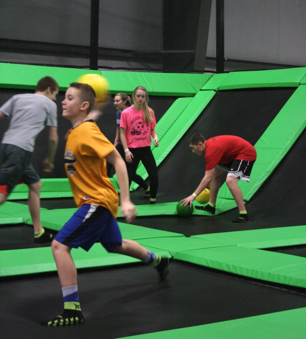 Group of people playing dodgeball on trampolines